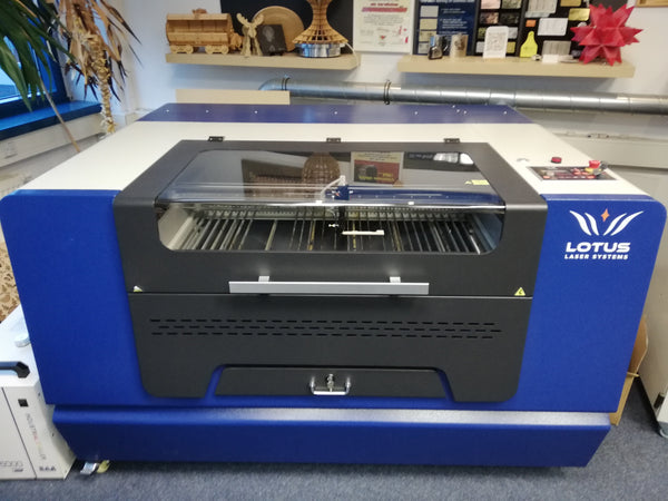 Lotus Blu 100 Maschine in blau und weiß mit schneidbrett, Glashaube, Not-Aus Knopf, Bedienungsmenu und Rollen am Boden.