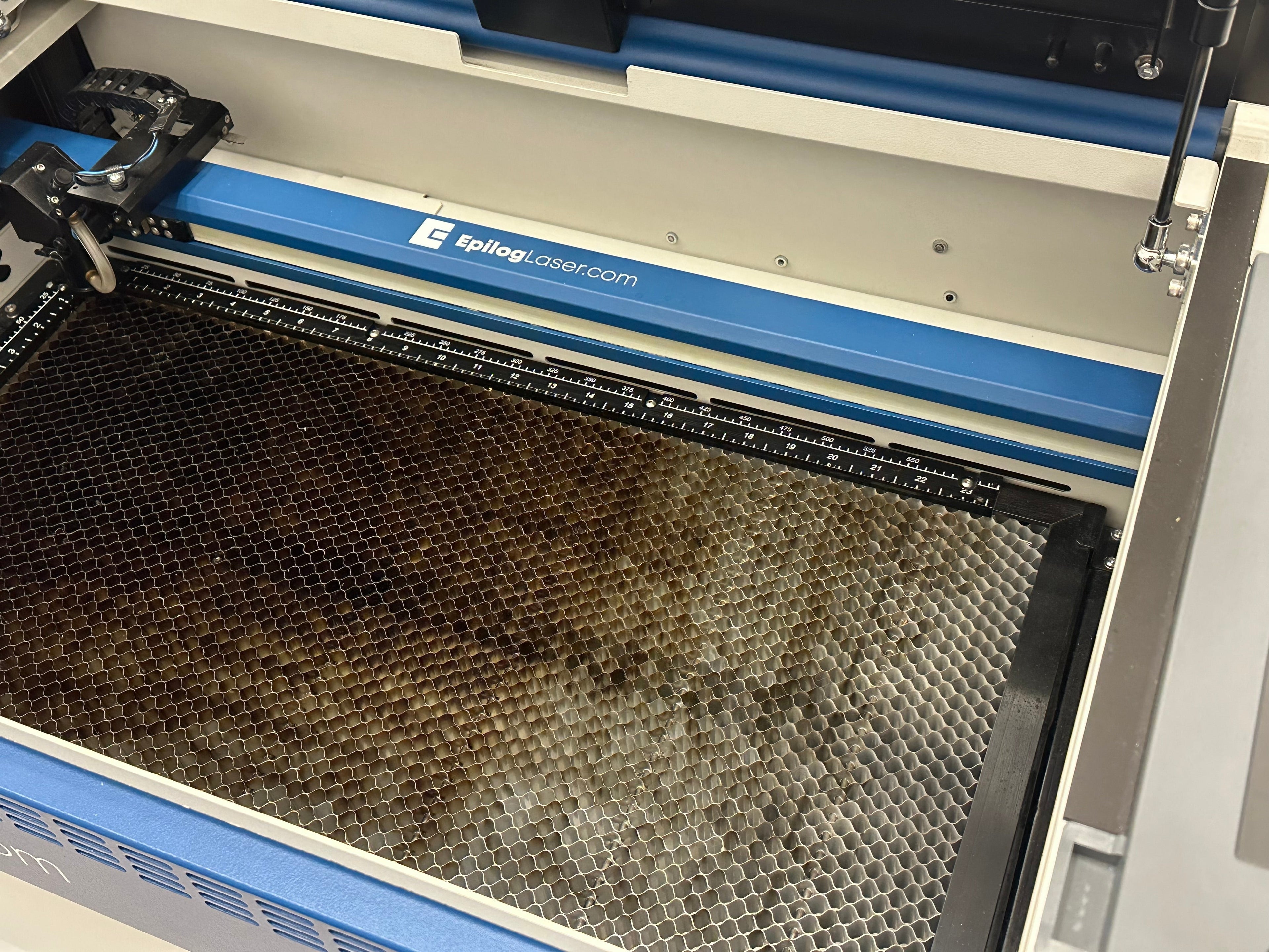 Geöffnete Epilog Fusion Edge 12 Maschine in Blau und Weiß mit Schneidtisch.